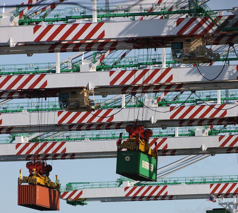 Cranes unloading containers off a ship.