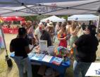 Two Port employees standing behind the Port booth speaking with communit members at Tacoma Pride.